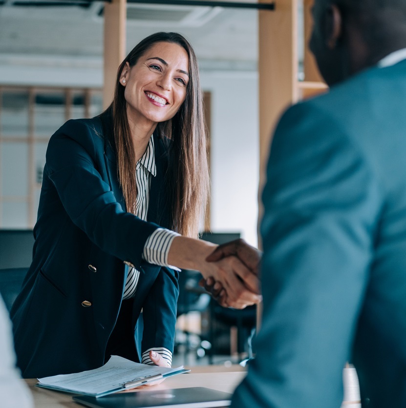Business people shaking hands in the office. Group of business persons in business meeting. Three entrepreneurs on meeting in board room. Corporate business team on meeting in modern office. Female manager discussing new project with her colleagues. Company owner on a meeting with two of her employees in her office.